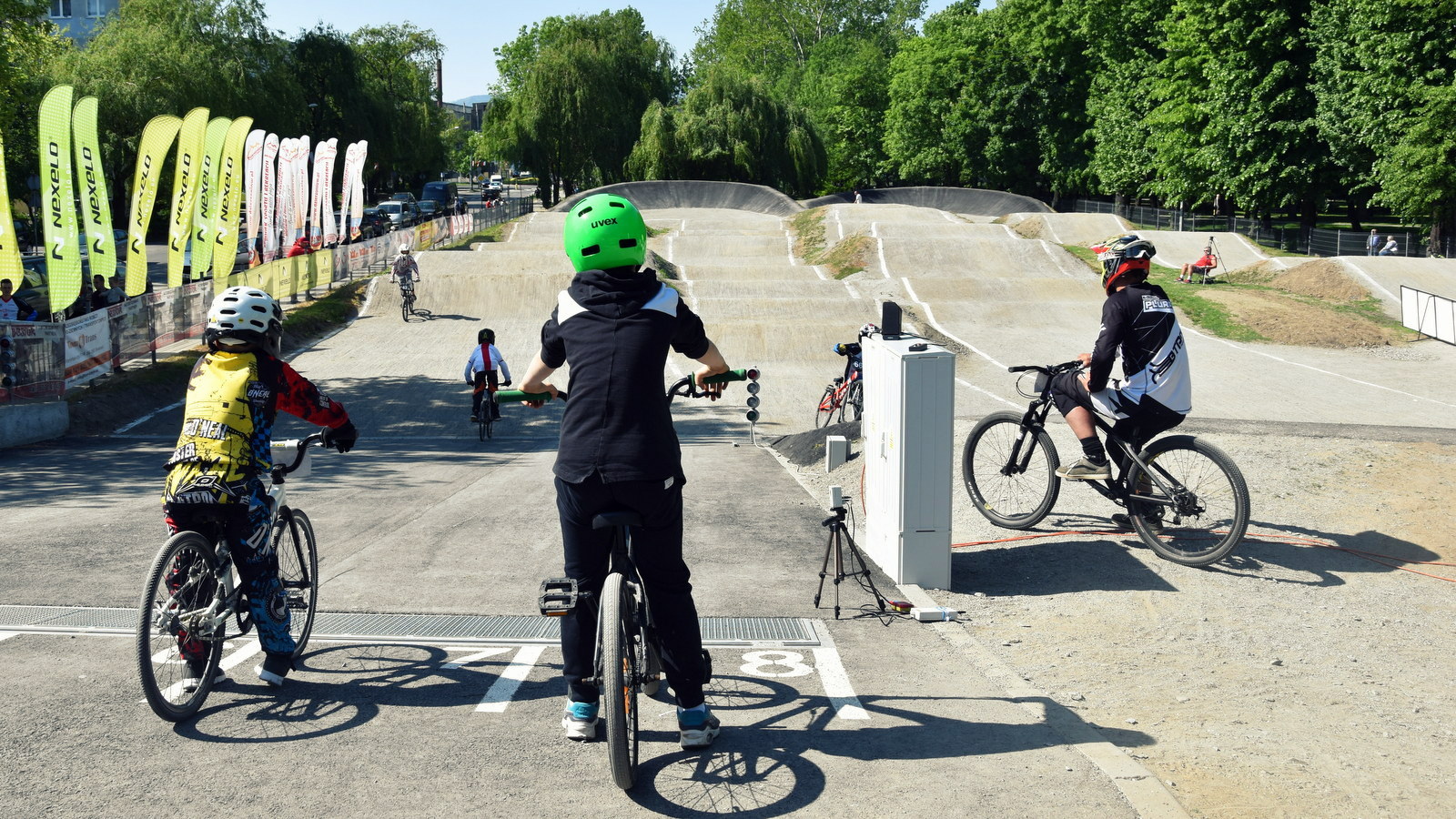 Tor do BMX, na pierwszym planie rowerzyści na platformie startowej