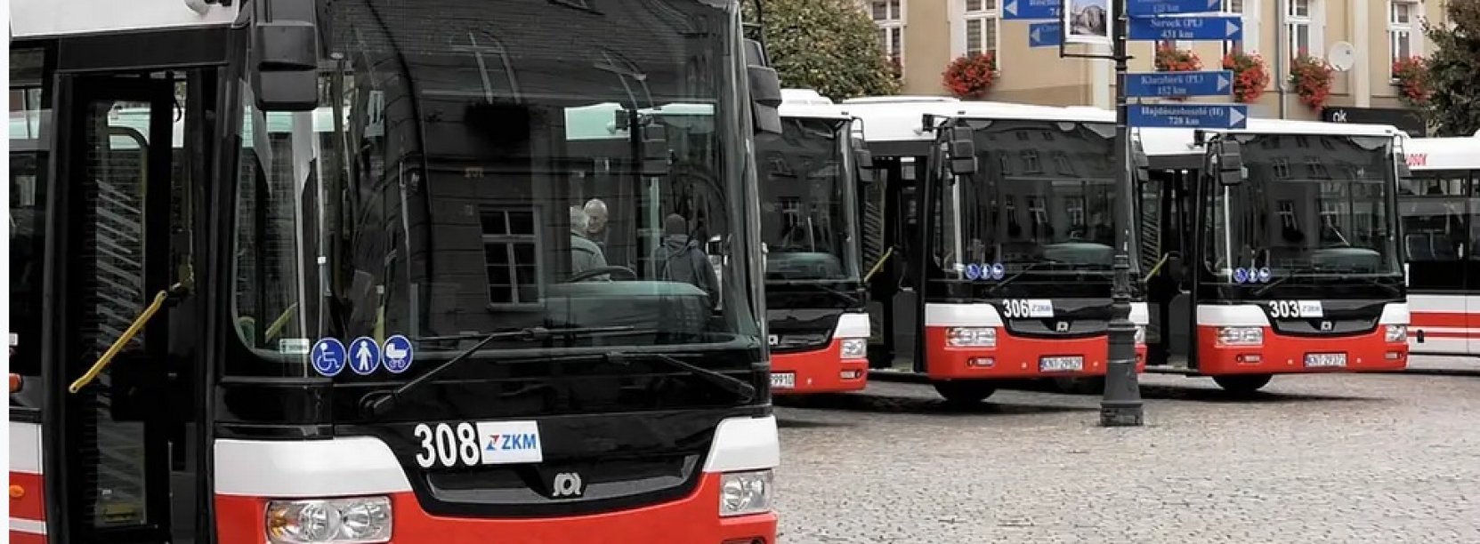 Czerwono-białe autobusy komunikacji miejskiej zaparkowane obok siebie 