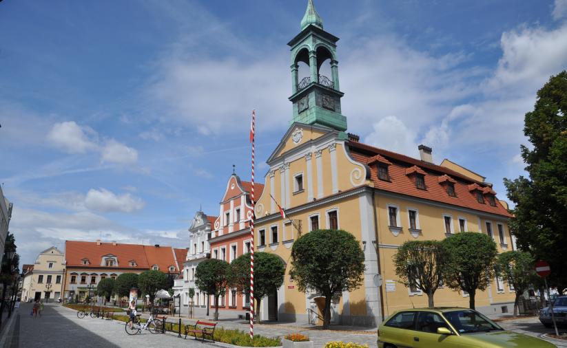 Budynek ratusza w Kluczborku otoczony drzewami