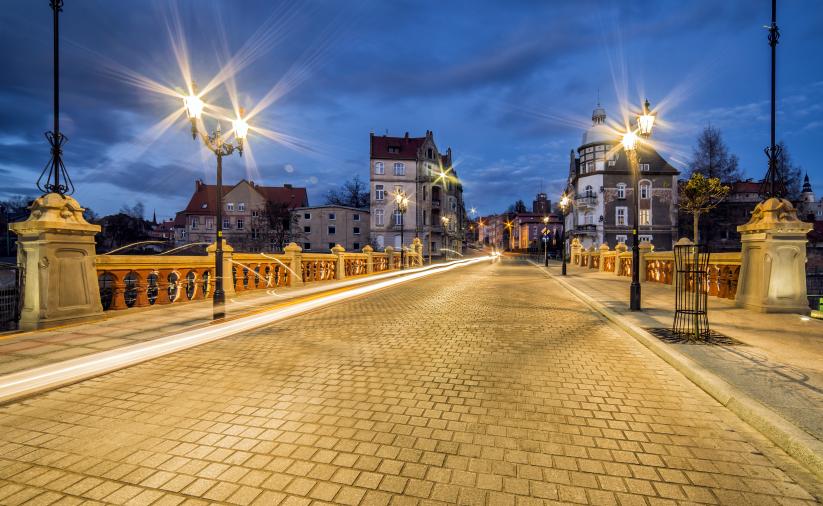 Nocne zdjęcie Moastu Niepodległości nad rzeką Piławą, na ul. Sienkiewicza