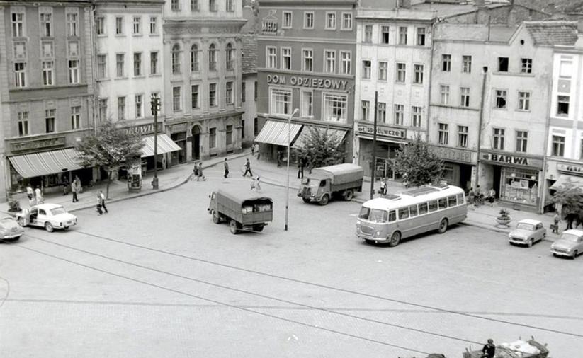 Południowo-zachodnia cześć rynku z zaparkowanymi autami, autobusem.