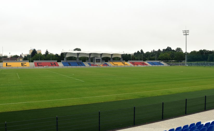 Zielona murawa na stadionie i kolorowe trybuny dla kibiców