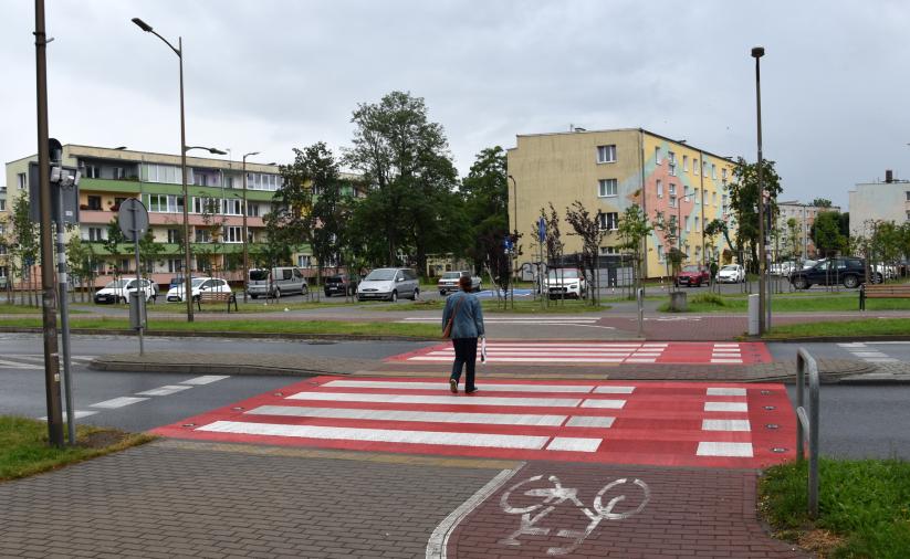 Widok przejścia aktywnego z przechodniem, na drugim planie budynki os. Kolorowego