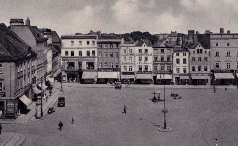 Przedwojenny rynek, kamienice, na parterach markizy, na rynku stojące stare automobile