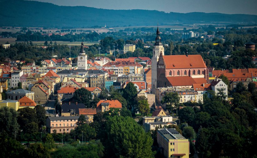 Starówka Dzierżoniowa z lotu ptaka, na pierwszym plane duży średniowieczny kościół, w tle góry