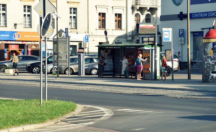 Przystanek autobusowy, na przystanków kilka osób czekających na autobus