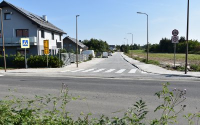 Widok na droge z kostki betonowej, obok budynki jednorodzinne