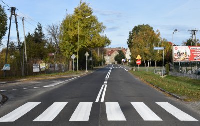 Prosta, pusta droga wjazdowa do miasta, na pierwszym planie przejście dla pieszych