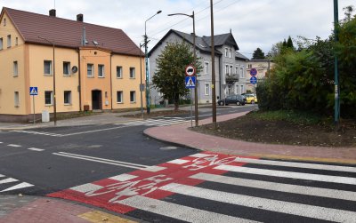 Szkrzyżoanie dróg, przejście dla pieszych i budynek z piaskową elewacją