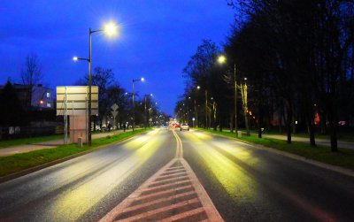 Dwupasmow droga nocą, po bokach świecące lampy, ciemnoniebieskie niebo