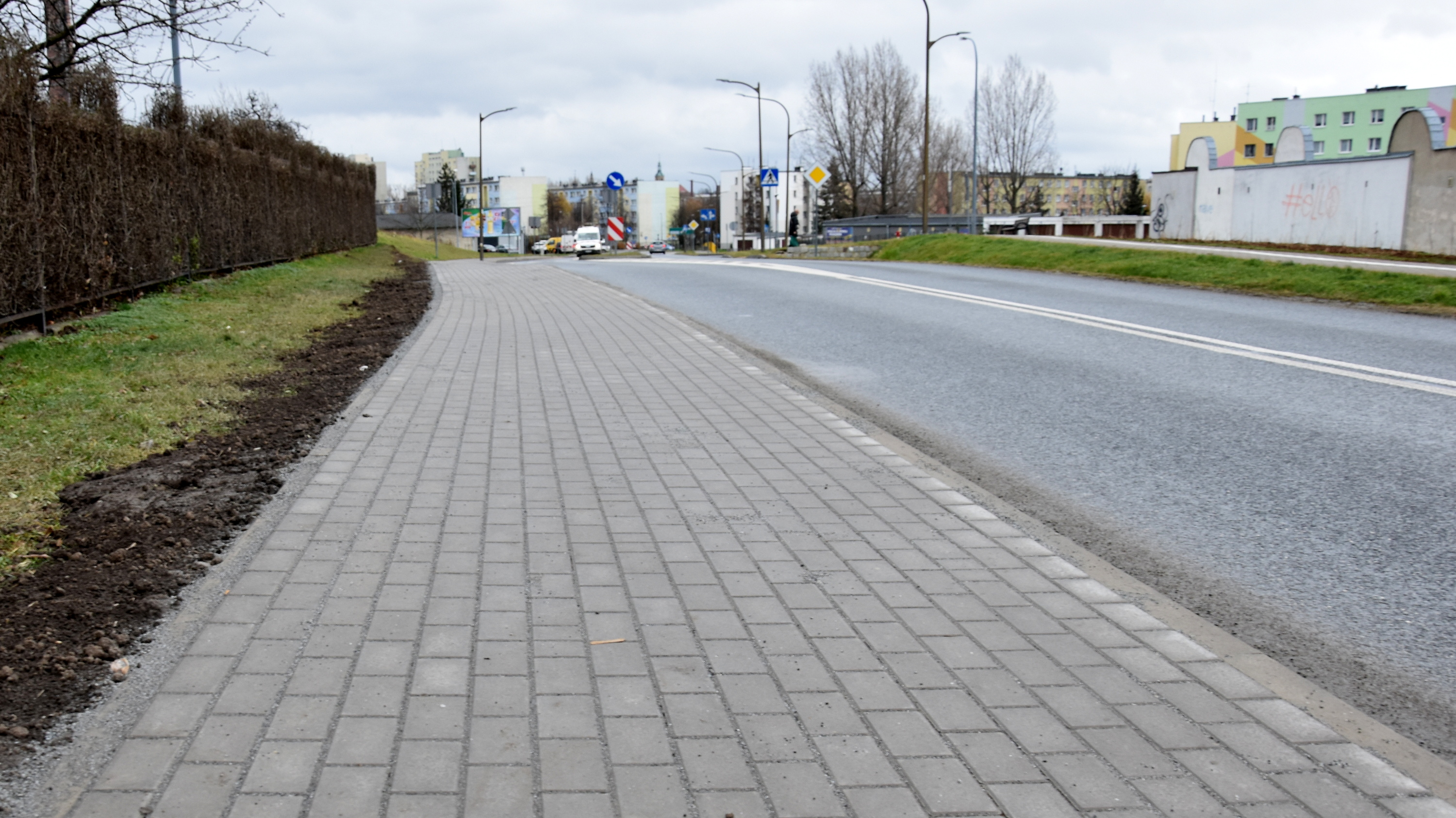 Nowy chodnik z kostki betonowej, w tle bloki mieszkalne