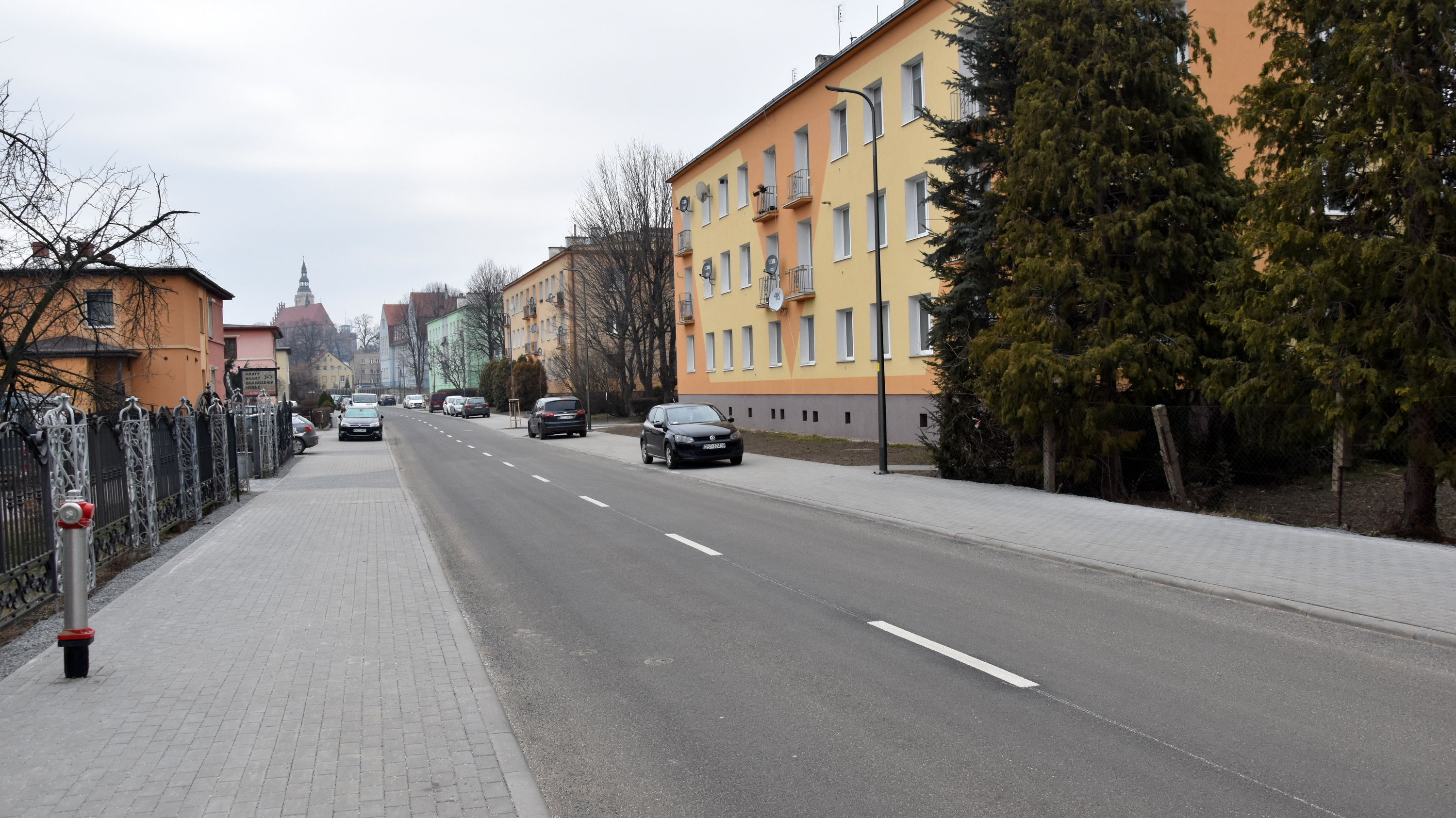 Ulica Słowiańska po remoncie, po bokach nowe chodniki, za nimi domy jedno i wielorodzinne