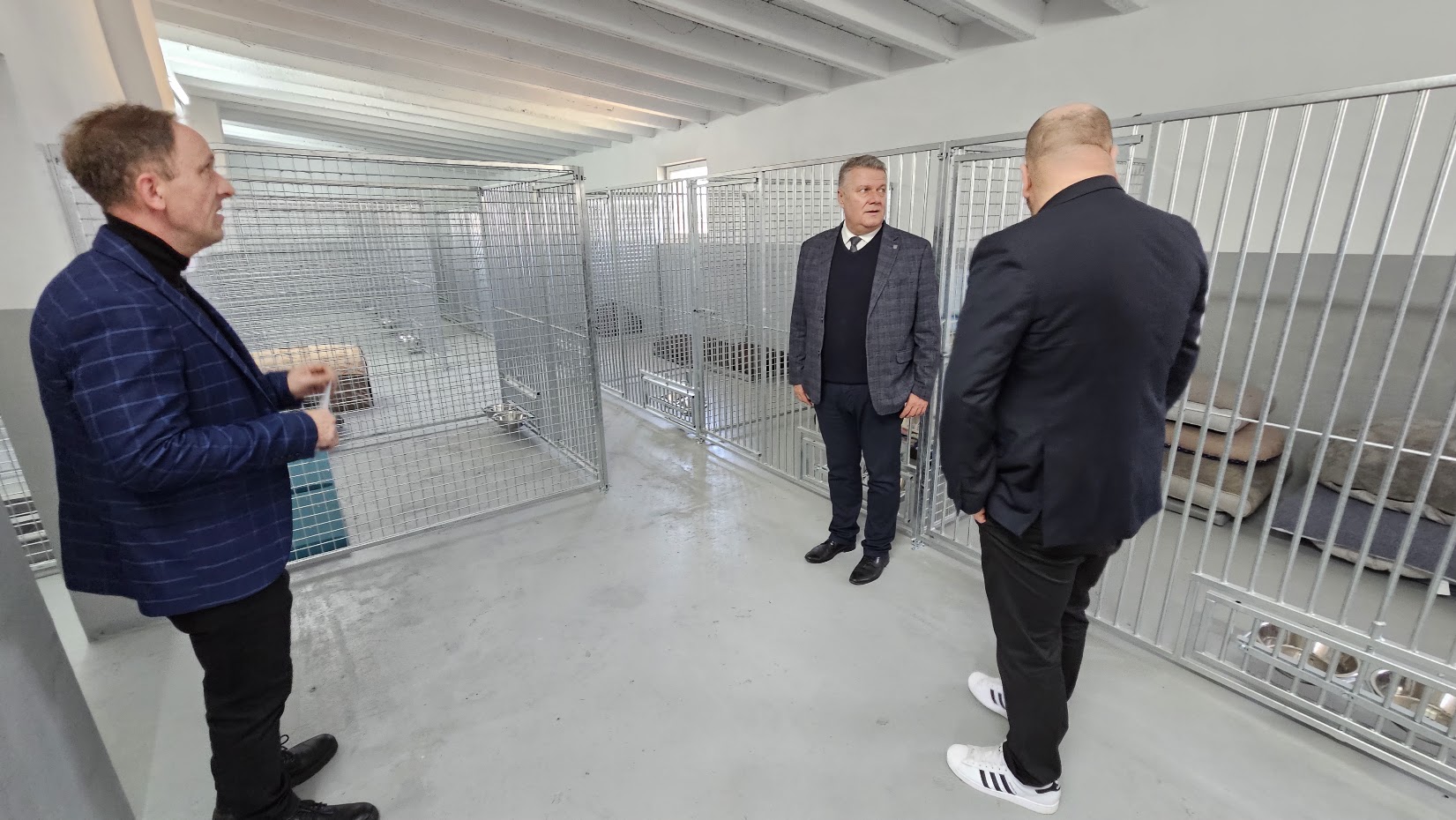 burmistrz Dzierz\oniowa, Draiusz Kucharski, wiceburmistrz Radosław Michałek i prezes schroniska Azyl wizytują nową halę ewakuacyjną