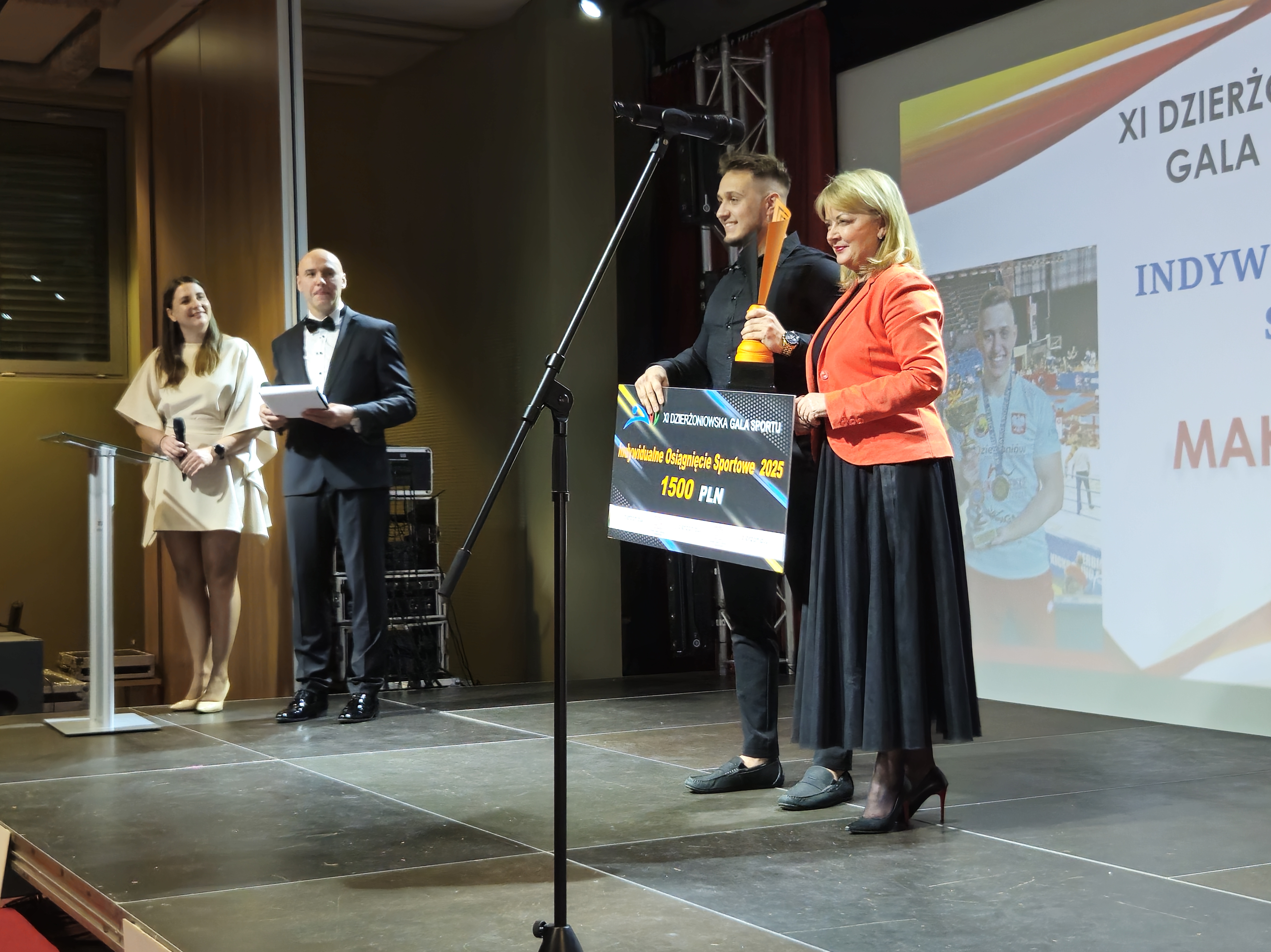 Maksymilian Palej odbierający nagrodę z rąk przewodniczącej kapituły Doroty Pieszczuch
