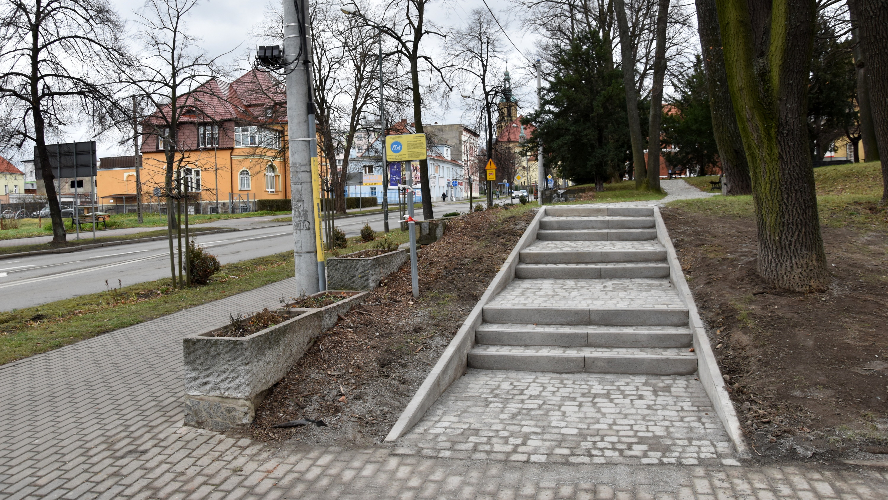 Kamienne schody prowadzące do małego parku przy drodze