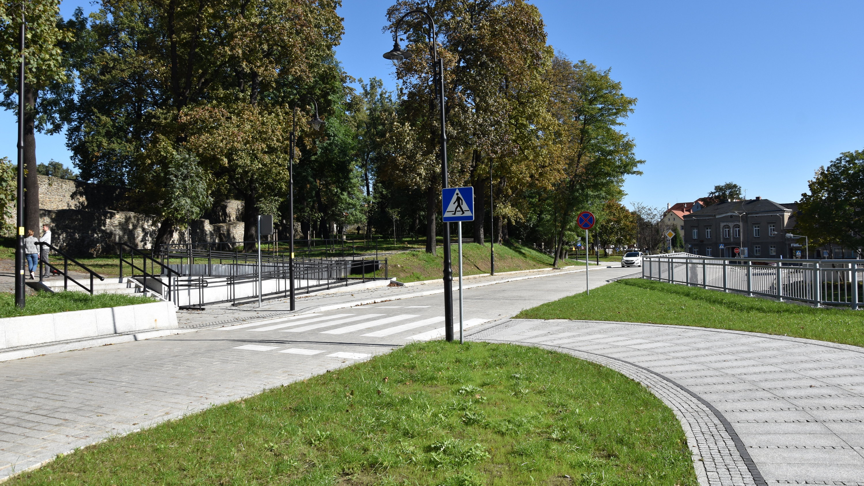 Droga z kostki kamiennej, po lewej średniowieczne mury i park