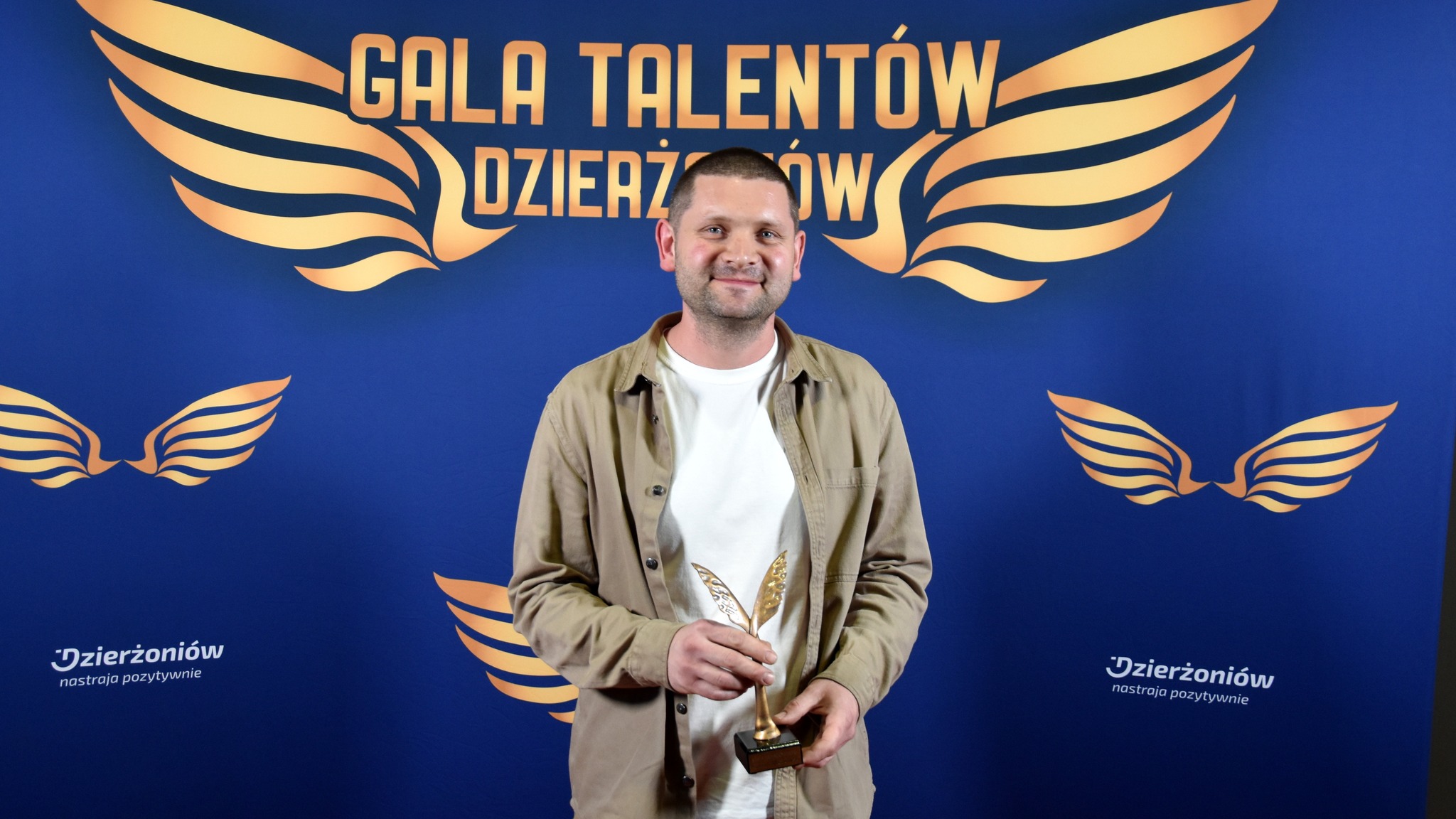 Roman Mrozowski trzymający w dłoniach statuetkę