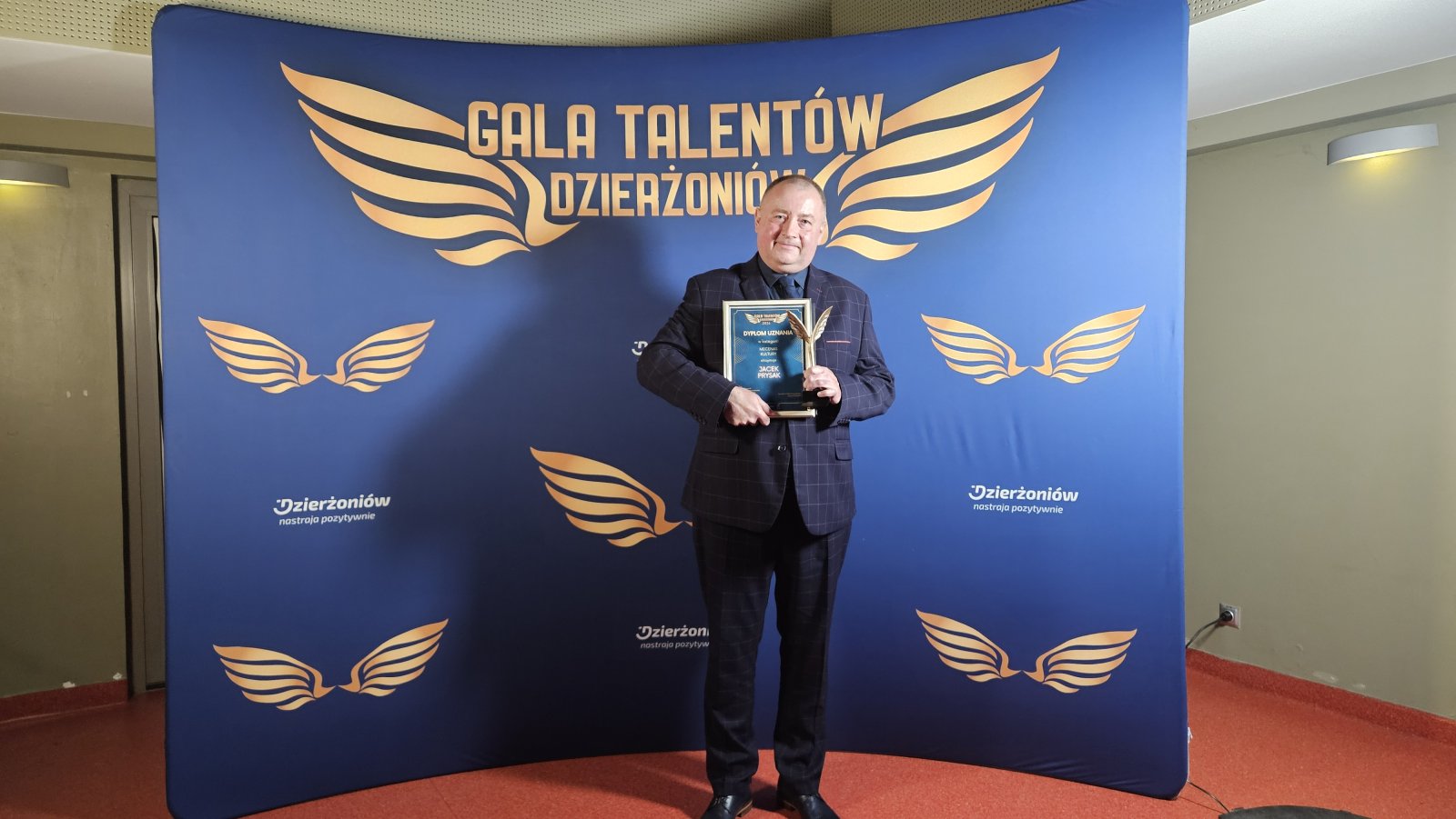 Jacek Prysak przed ścianką z napisem Gala Talentów Dzierżoniów