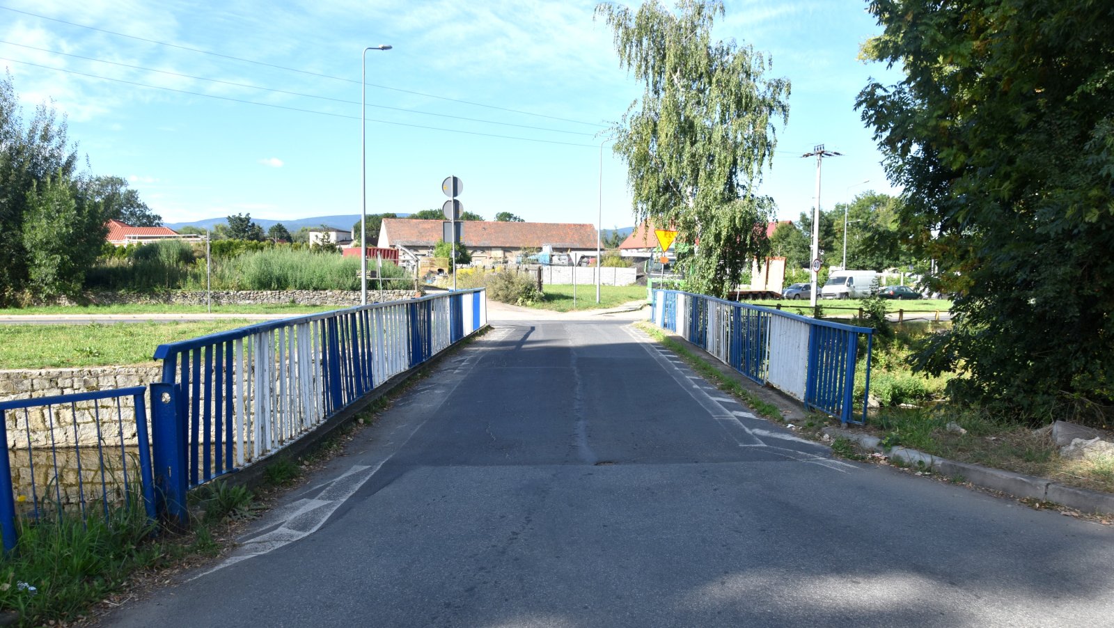 Most nad rzeką Piławą, po bokach niebiesko-białe balustrady