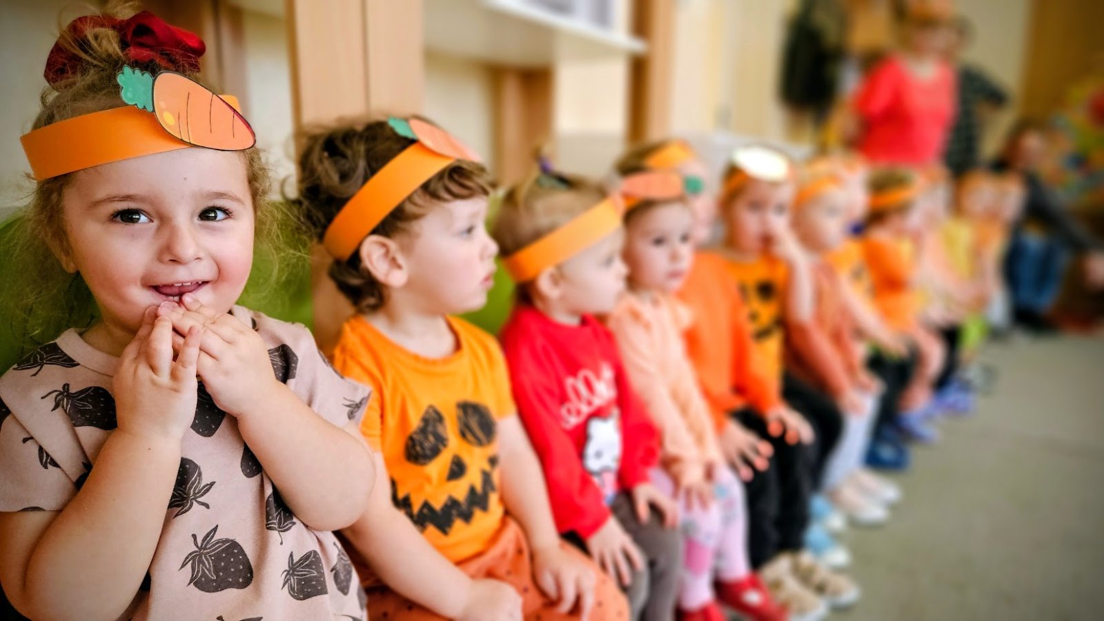 małe dzieci grają na instrumetach perskusyjnych z opiekunką