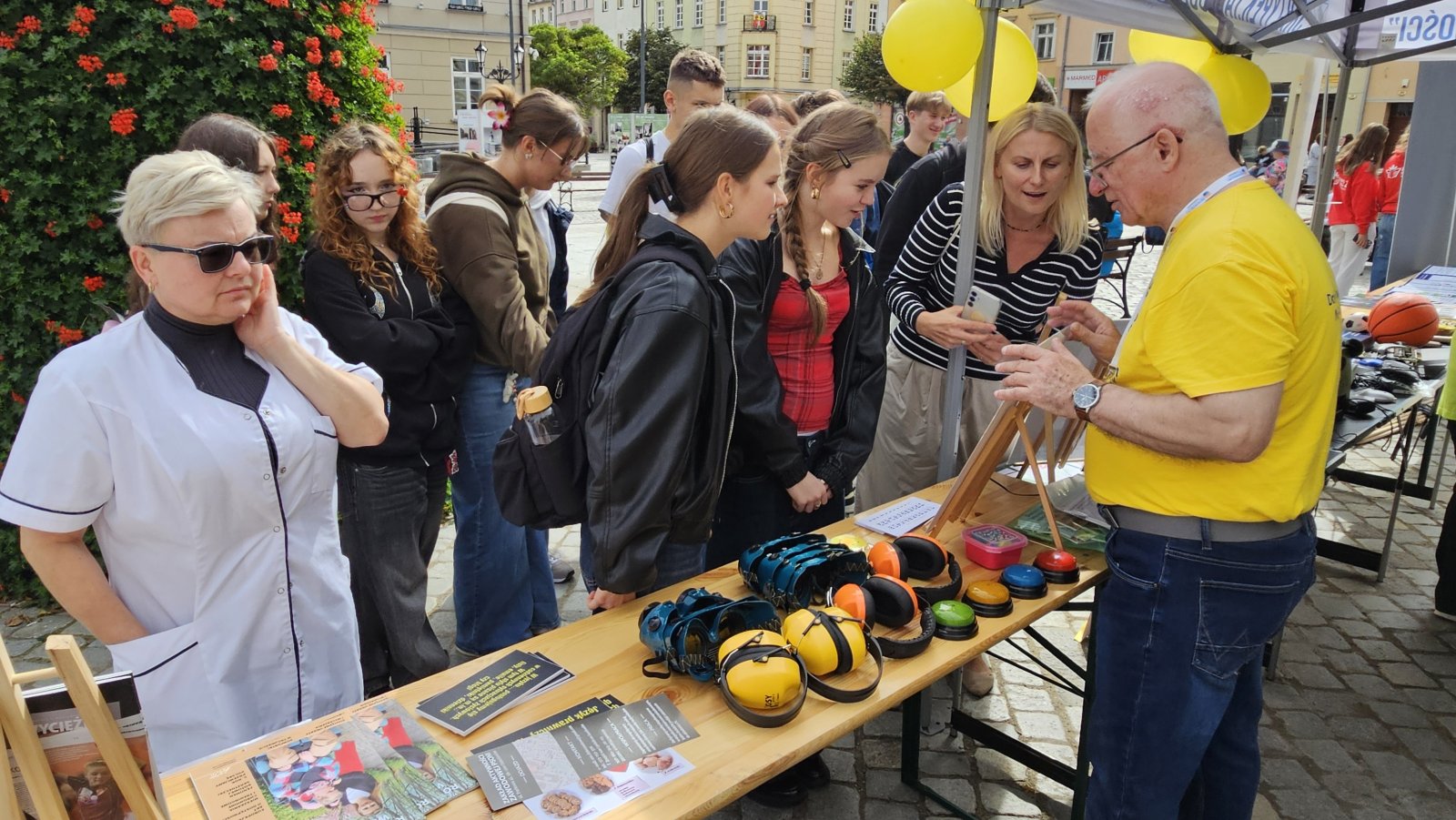 Stoisko dla osób z problemami słuchu, przed stoiskiem młodzież