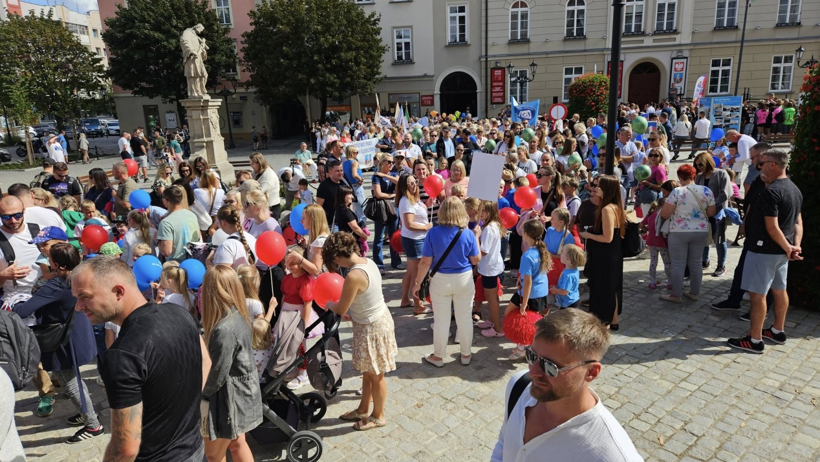 Tłum mieszkańców z kolorowymi balonami na rynku