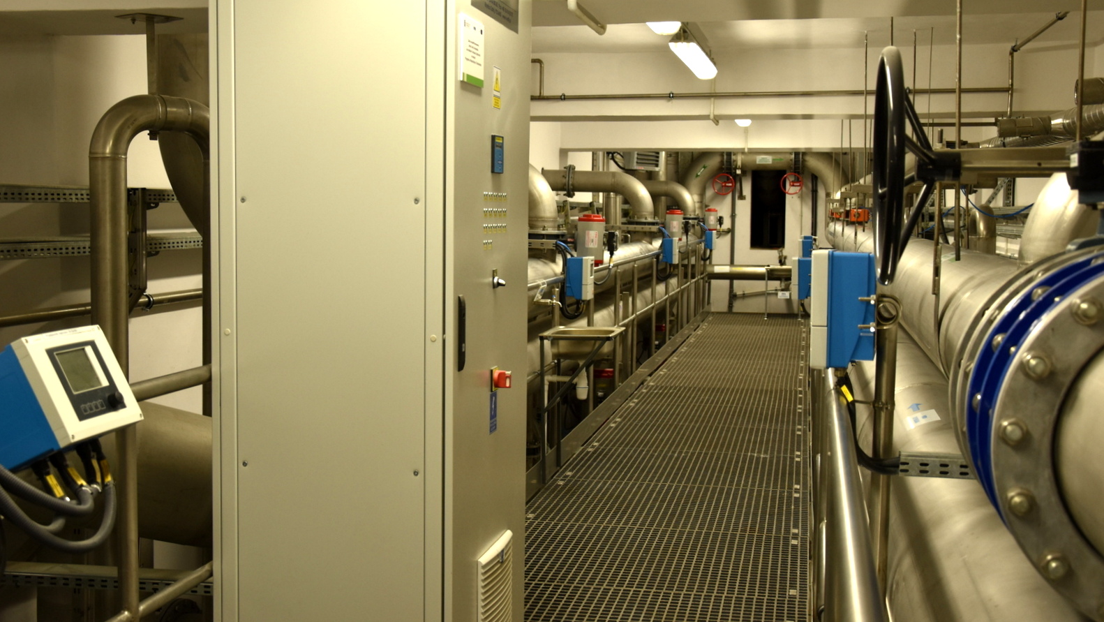 Duże wnętrze wypełnione systemem rur i urządzeń do oczyszczania wody