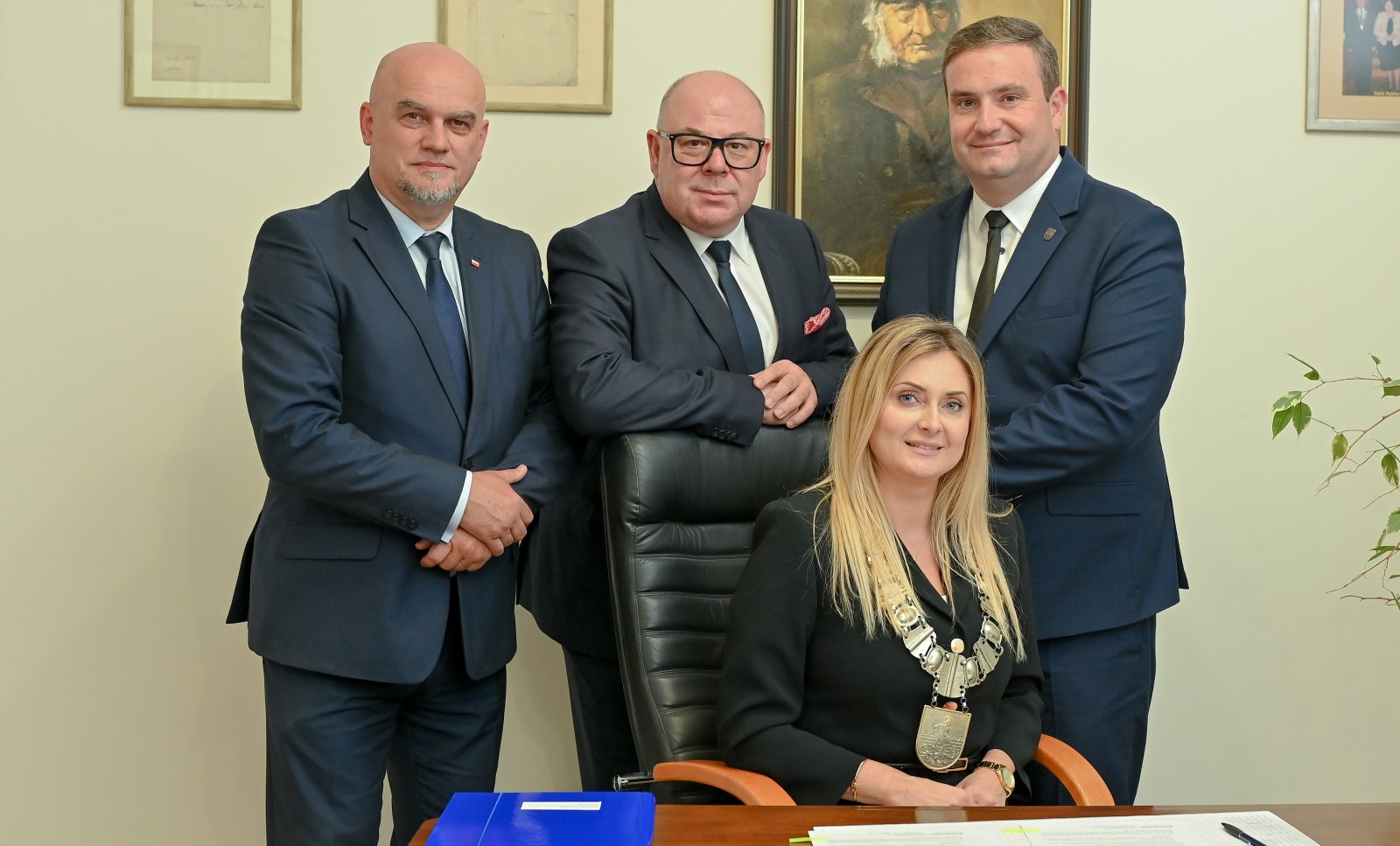 Przewodnicząca rady siedząca przy biurku, za nią trzech wicerzewodniczących