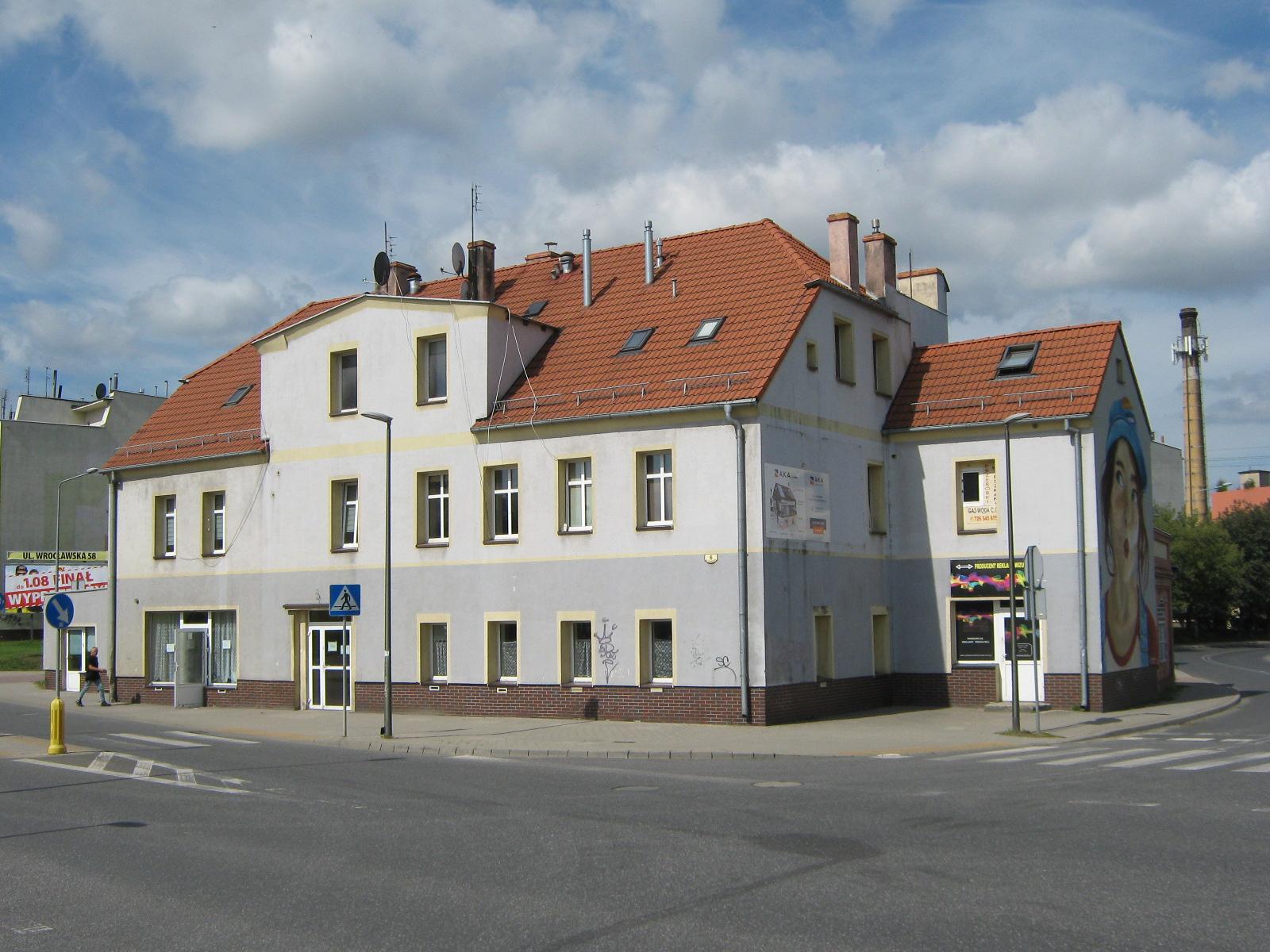 Kamienica przy skrzyżowaniu dróg, na jednej ze ścian mural przedstawiający twarz kobiety