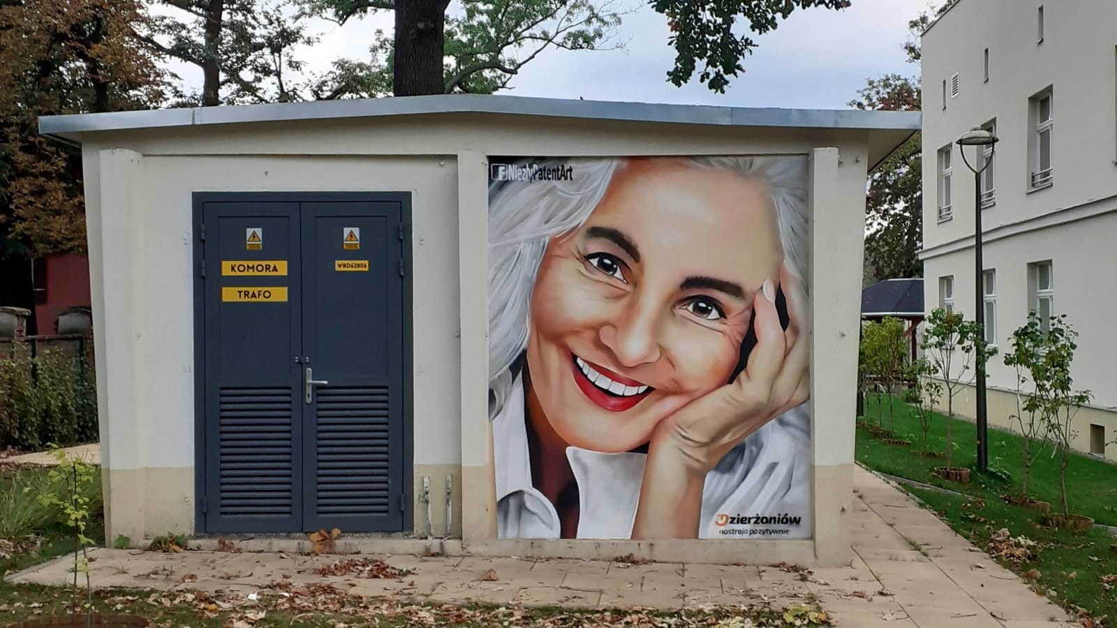 Mural,, twarz uśmiechniętej seniorki