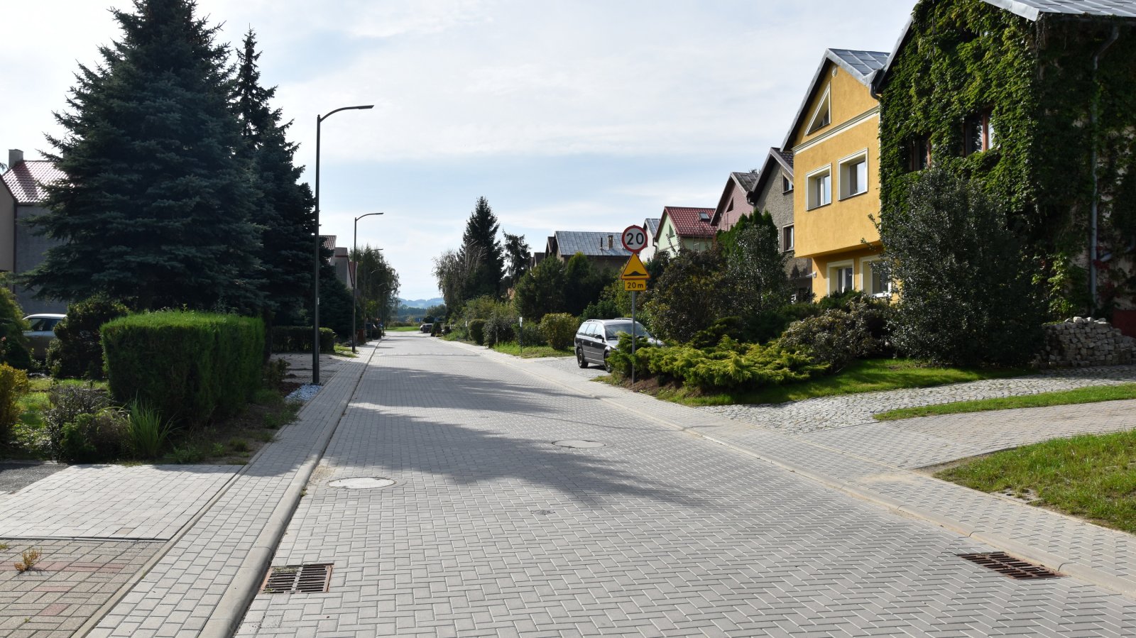 Nowa droga i chodniki z kostki betonowej, po bokach domki jednorodzinne