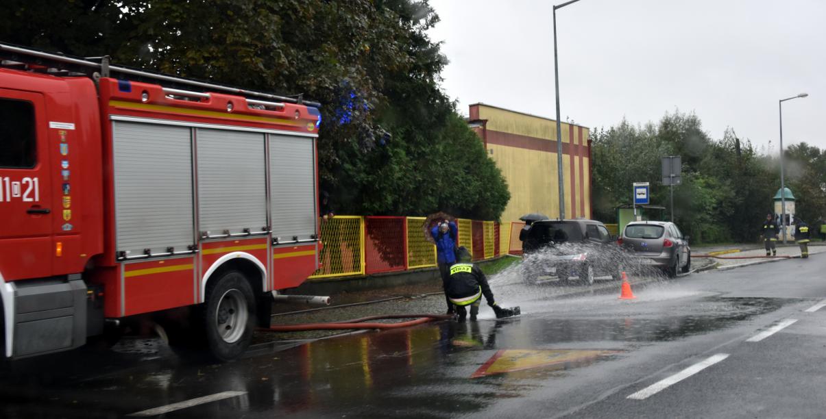 Strażakpracujący przy wypompowywaniu wody ze studzienki 