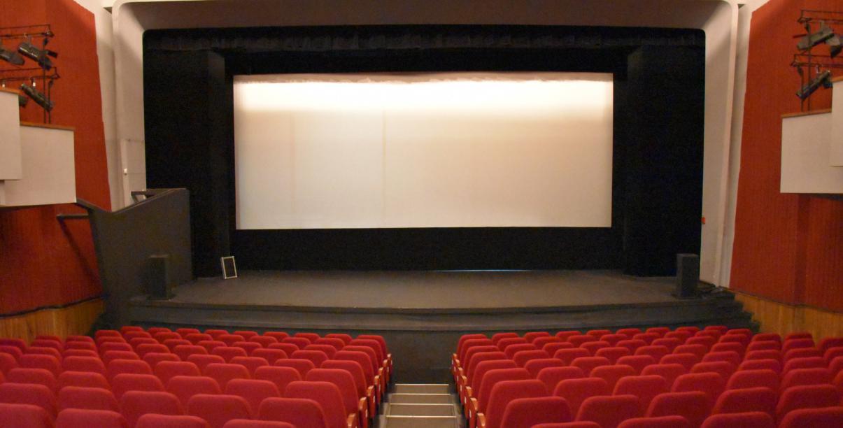 Pusta sala kinowa z białym ekranem 