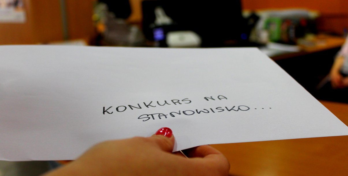 Na zdjęciu ręka, w której jest koperta z napisem "Konkurs na stanowisko..."