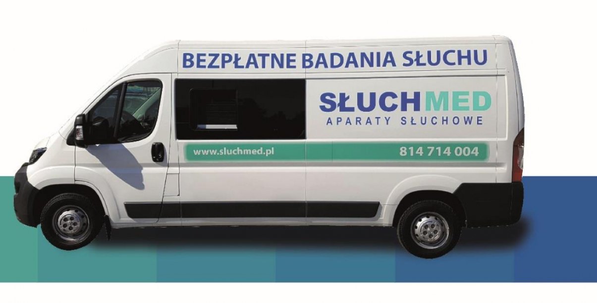 Biały bus z napisem Bezpłatne badania Słuchu