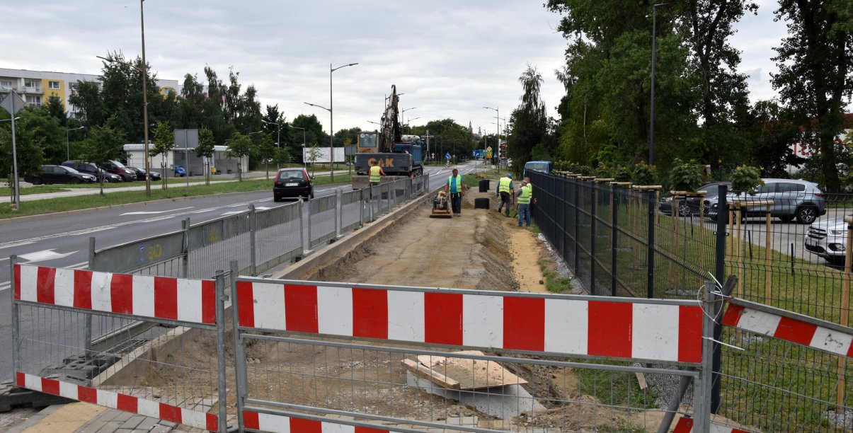 Ogrodzone miejsce przy drodze, pracownicy budujący chodnik