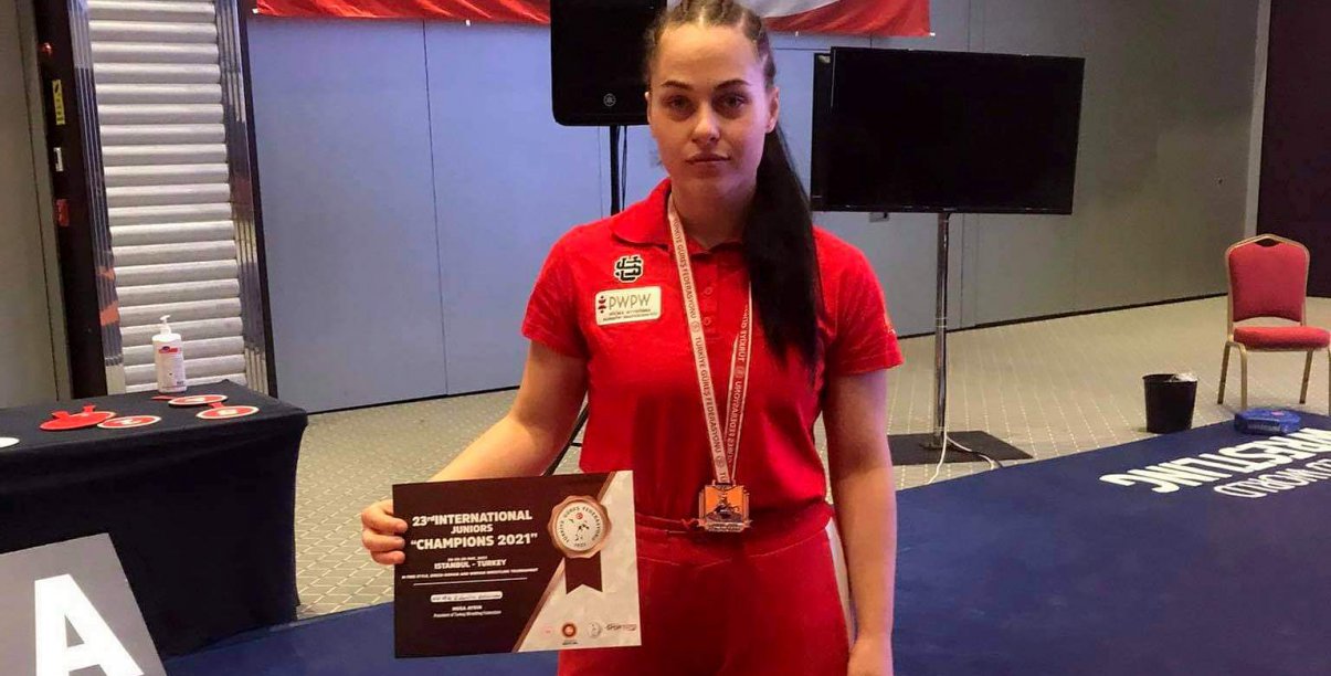 Dziewczyna w czerwonej koszylce ze sporowym trofeum w ręce