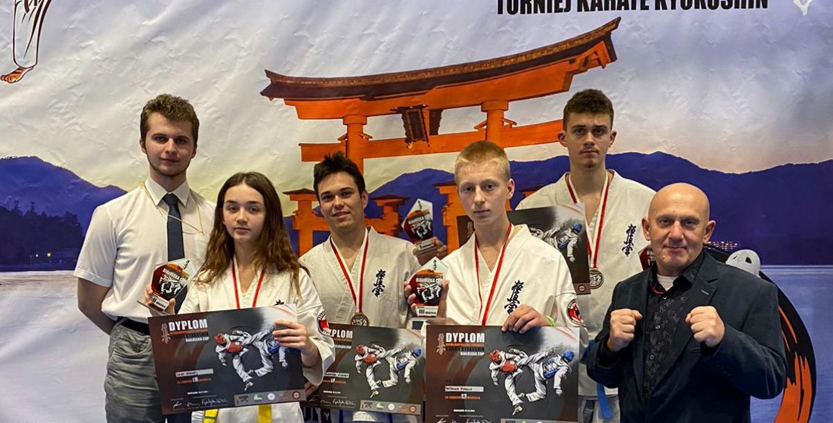 Grupowe zdjęcie zawodników strojach karate i z dyplomami