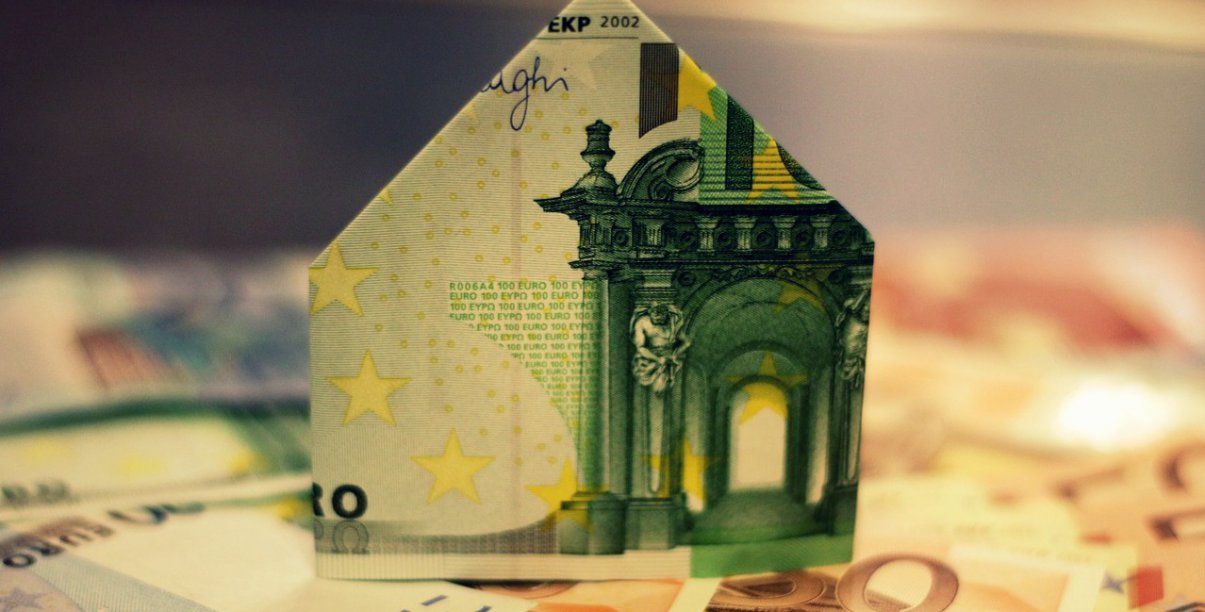 Banknot eur złozony w domek stojący na leżacych banknotach