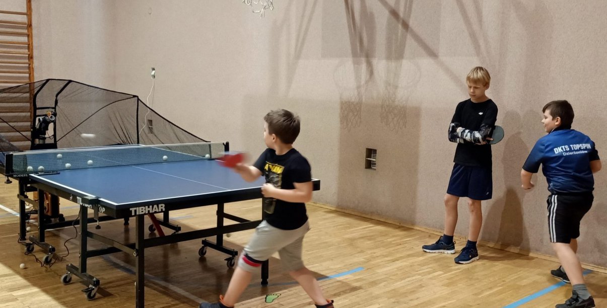 Trójka dzieci przy stole pingpongowym