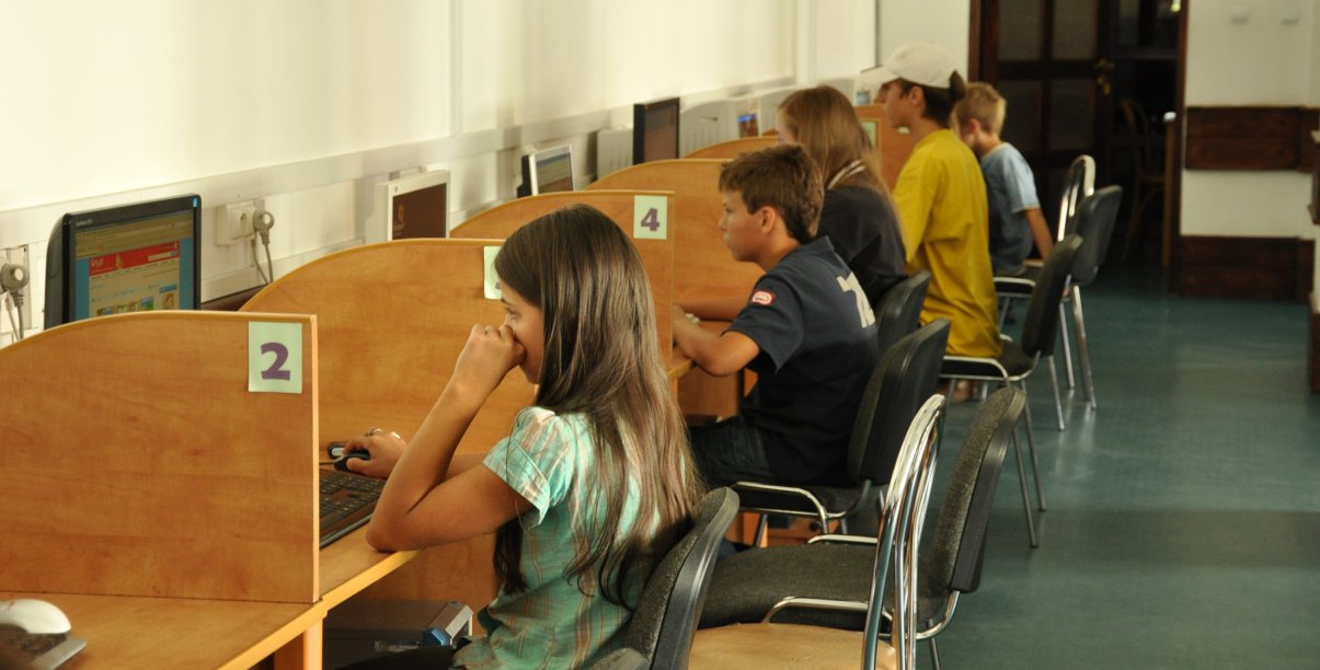 Uczniowie przy stanowiskach komputerowych