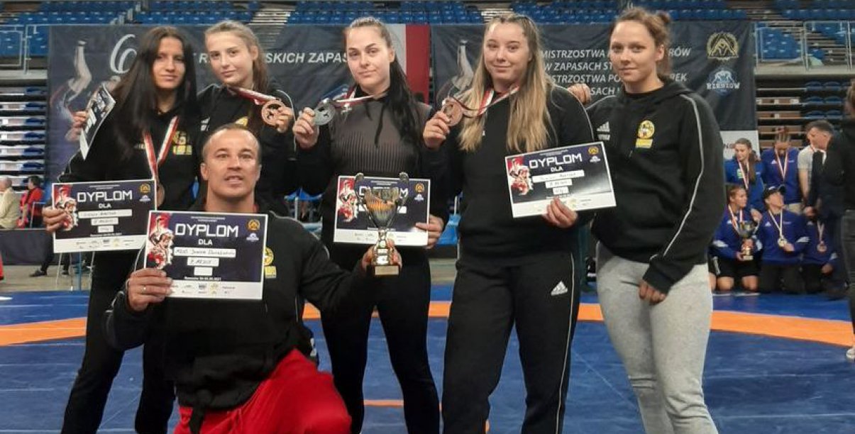 Zawodniczki i trener w sportowych strojach