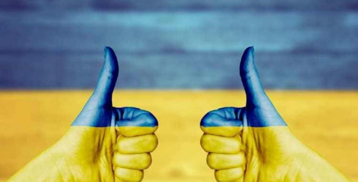 Dwie dłonie z wyciągnietym w góre kciukiem w barwach flagi Ukrainy