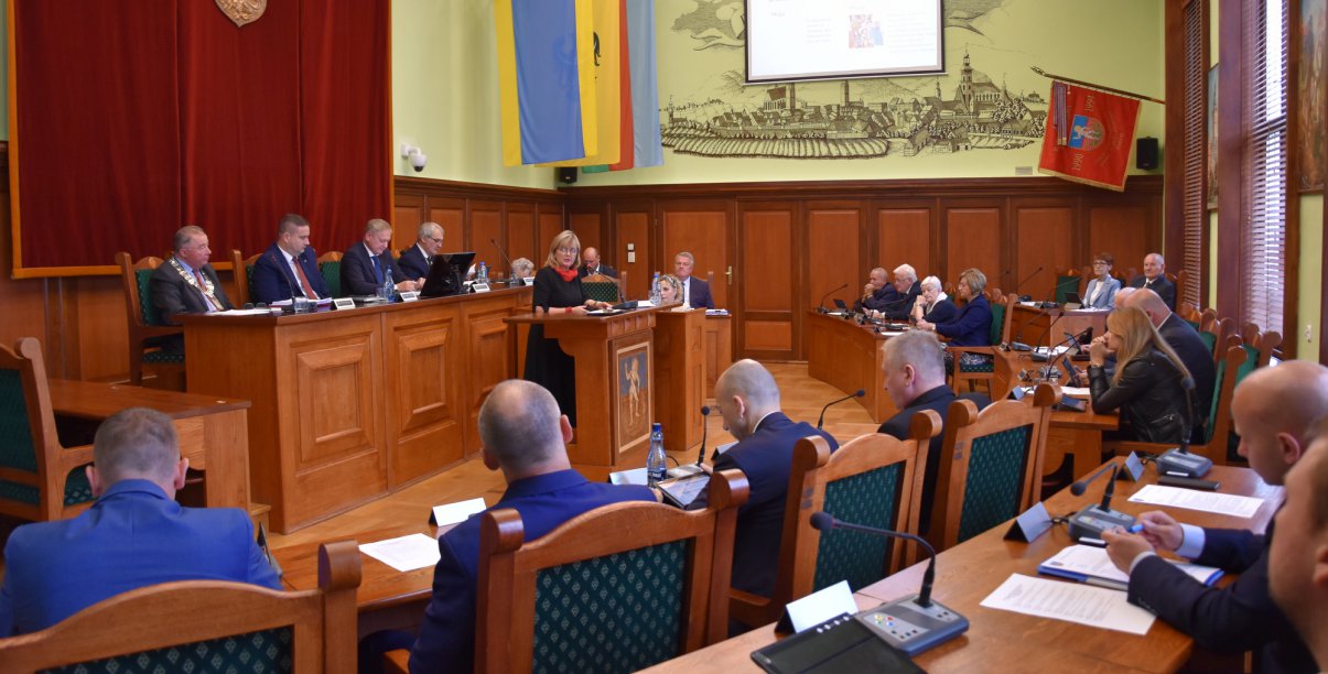 Sala obrad z radnymi siędzącymi przy stołach