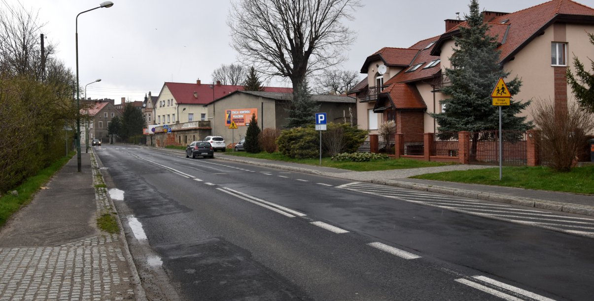 Pusta droga w mieście, deszczowa pogoda, po prawej stronie kamienice 