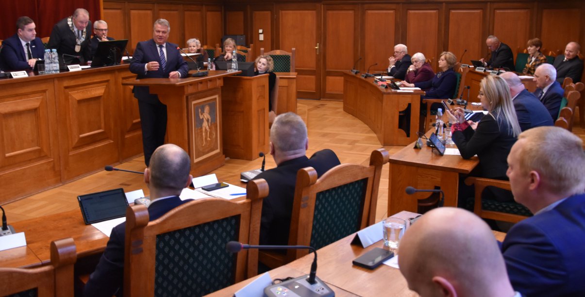 Duża sala wypełniona ludźmi - miejsce obrad rady miejskiej