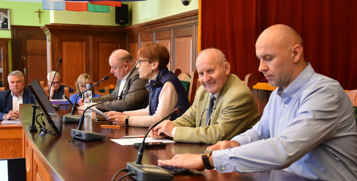 Czetry osoby siedzące przy długim stole
