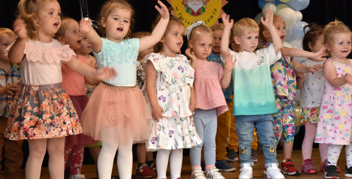 Grupa małych dzieci śpiewających piosenkę