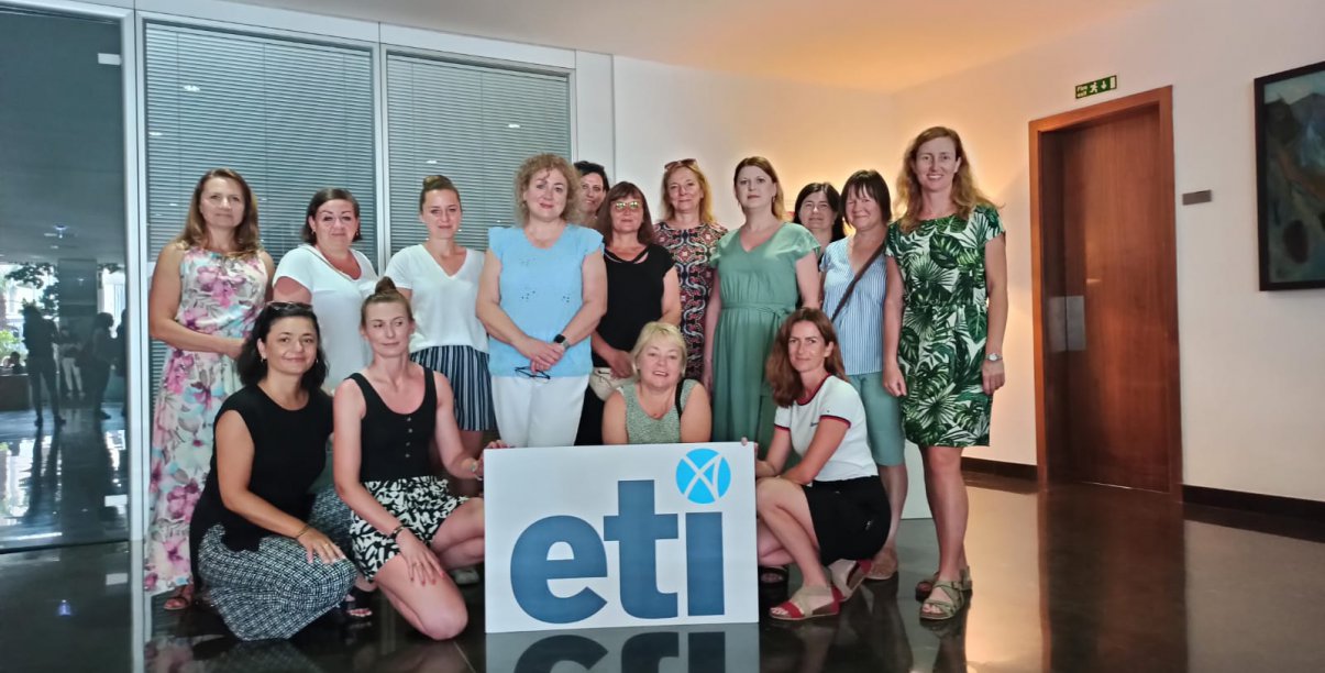 Grupa nauczycielek, trzyma tablicę z logotypem ETI