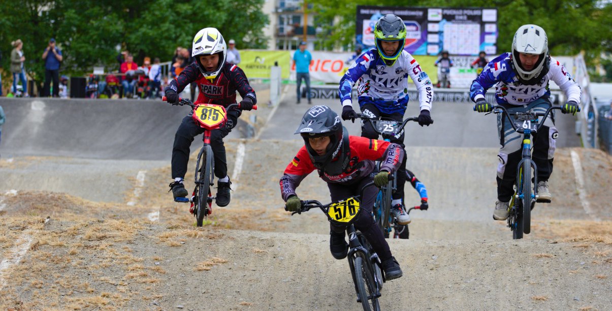 Czwórka młodych rowerzystów jadących po torze BMX